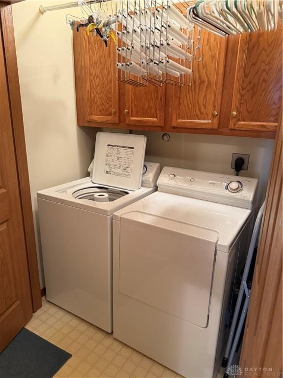 laundry area with washer and dryer and cabinets