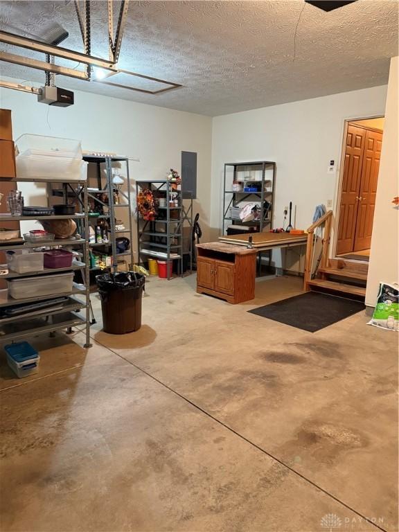 garage with electric panel and a garage door opener