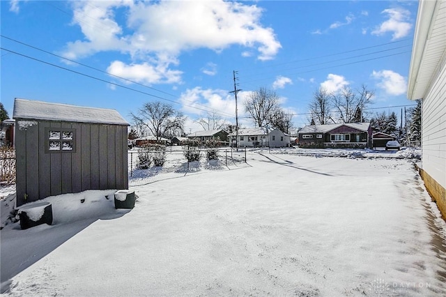 yard layered in snow with a storage unit