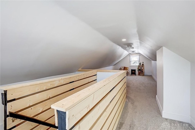 bonus room with vaulted ceiling and light colored carpet