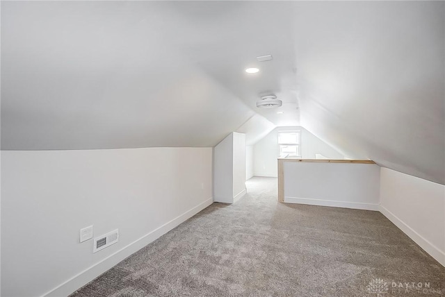 additional living space featuring carpet and lofted ceiling