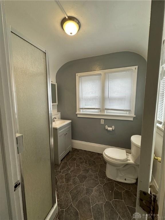 bathroom with toilet, vanity, and walk in shower