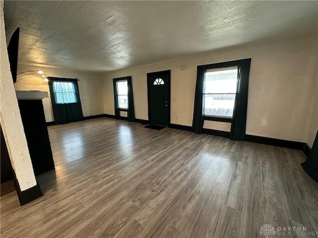 unfurnished living room featuring a textured ceiling and hardwood / wood-style flooring