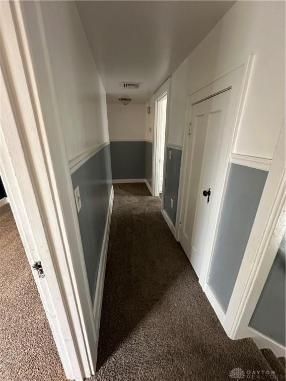 corridor featuring dark colored carpet