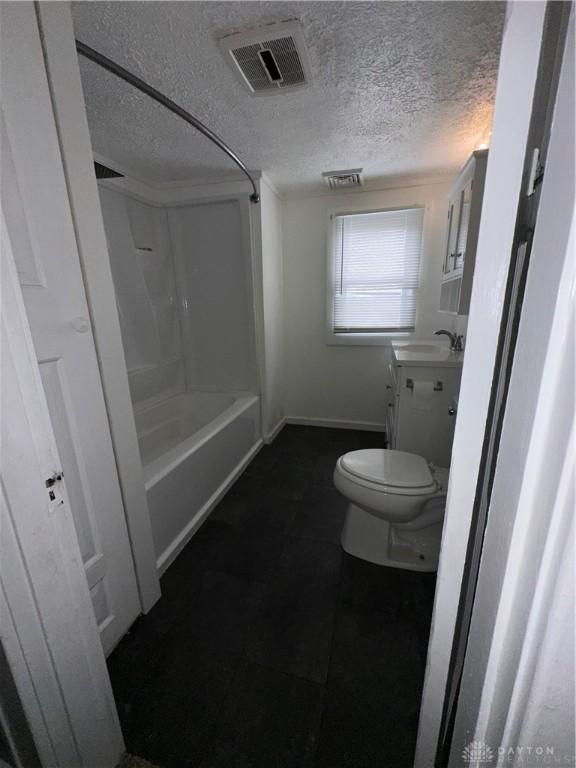 bathroom with vanity, toilet, and a textured ceiling