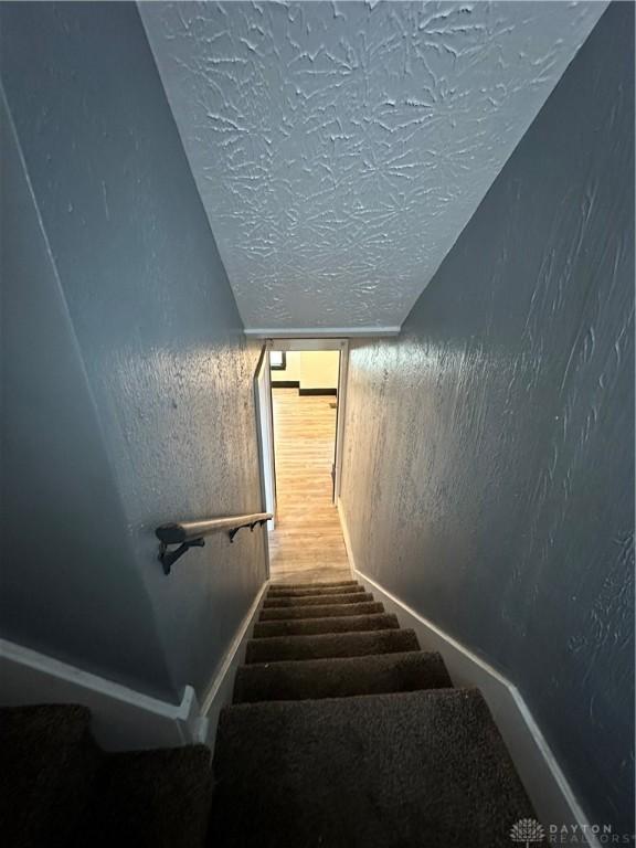 stairs with a textured ceiling