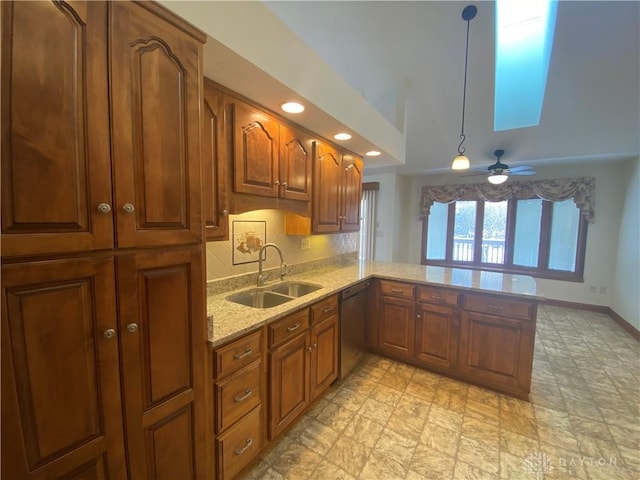 kitchen with kitchen peninsula, hanging light fixtures, black dishwasher, sink, and light stone counters