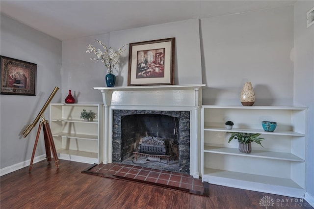 living room with hardwood / wood-style floors and a tiled fireplace