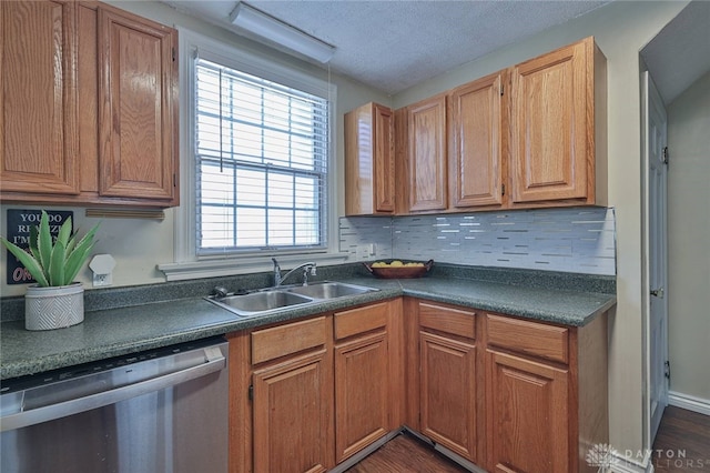 kitchen with sink, a textured ceiling, dark hardwood / wood-style flooring, stainless steel dishwasher, and tasteful backsplash