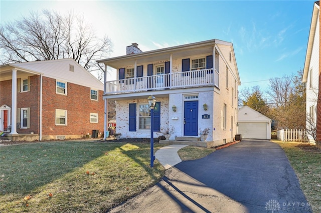 front of property featuring a front lawn, an outdoor structure, a garage, and a balcony