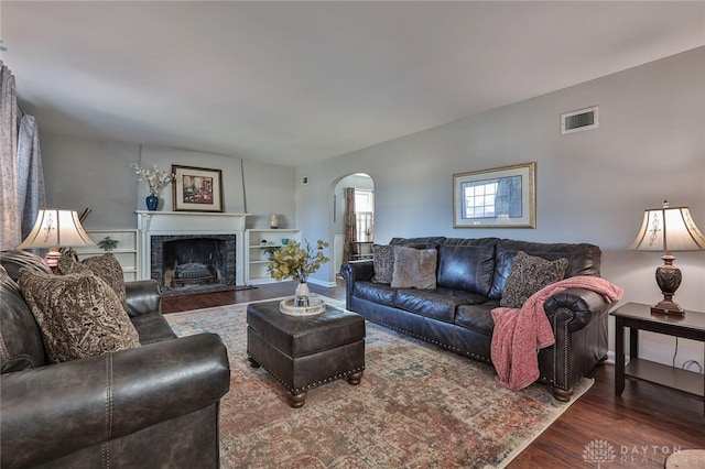 living room featuring a high end fireplace and dark hardwood / wood-style floors