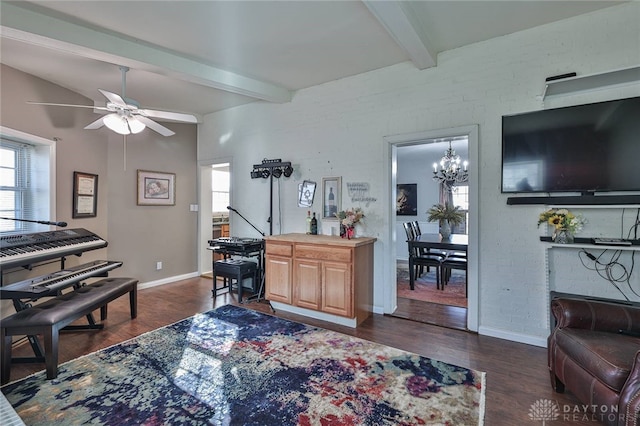 living room with beam ceiling, brick wall, dark hardwood / wood-style flooring, and ceiling fan with notable chandelier