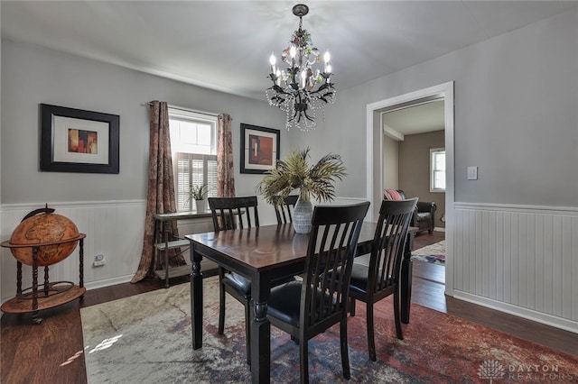 dining room with dark hardwood / wood-style flooring, an inviting chandelier, and a wealth of natural light