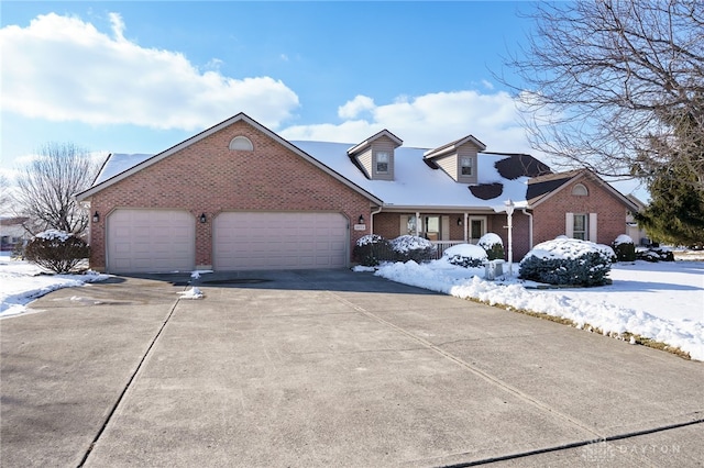 cape cod-style house featuring concrete driveway, brick siding, and an attached garage