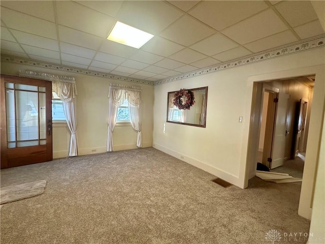 empty room with carpet floors and a paneled ceiling