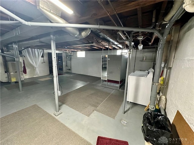 basement featuring heating unit and washer / clothes dryer