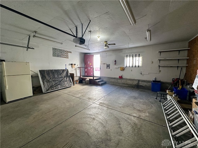 garage with a garage door opener and white fridge