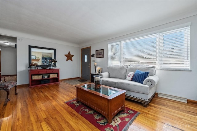 living room with visible vents, light wood-style flooring, and baseboards