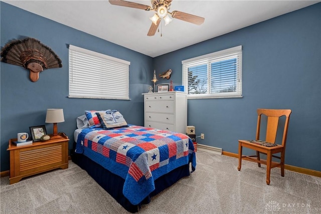 bedroom featuring light carpet, a ceiling fan, and baseboards