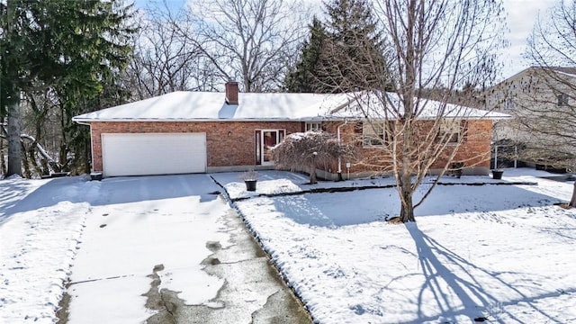 single story home featuring a chimney, a garage, and brick siding