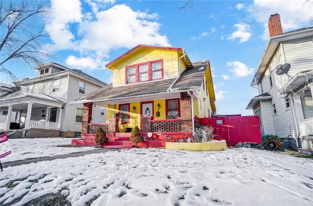 view of front of home featuring covered porch and fence