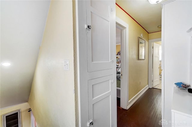 corridor with dark wood-style floors and baseboards