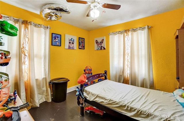 bedroom with a ceiling fan and baseboards