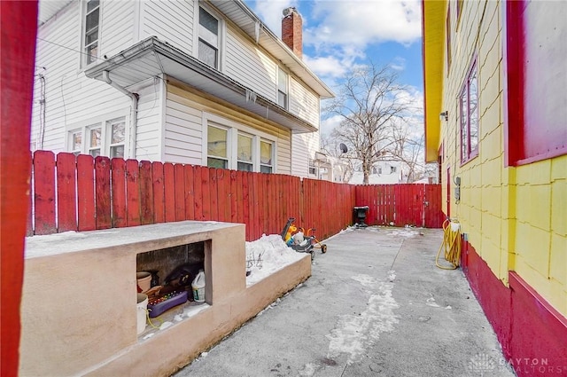 view of side of property featuring a fenced backyard and a chimney