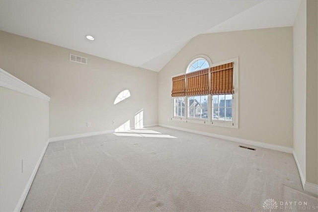 interior space featuring lofted ceiling, carpet flooring, visible vents, and baseboards