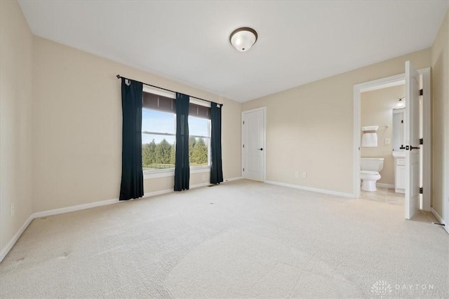 unfurnished room with baseboards and light colored carpet