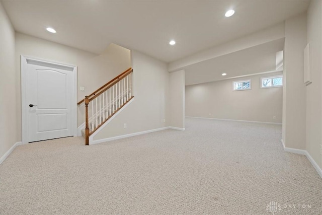 basement featuring recessed lighting, light carpet, baseboards, and stairs