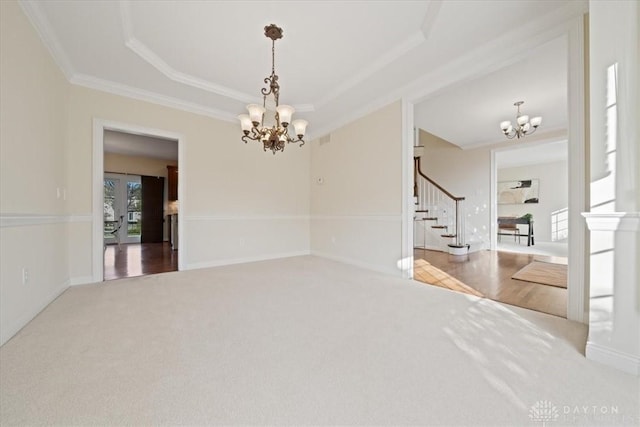 carpeted empty room with a chandelier, baseboards, stairs, a raised ceiling, and crown molding