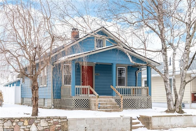 bungalow with a porch and a chimney