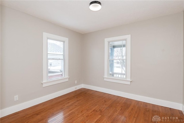 unfurnished room with baseboards and wood finished floors