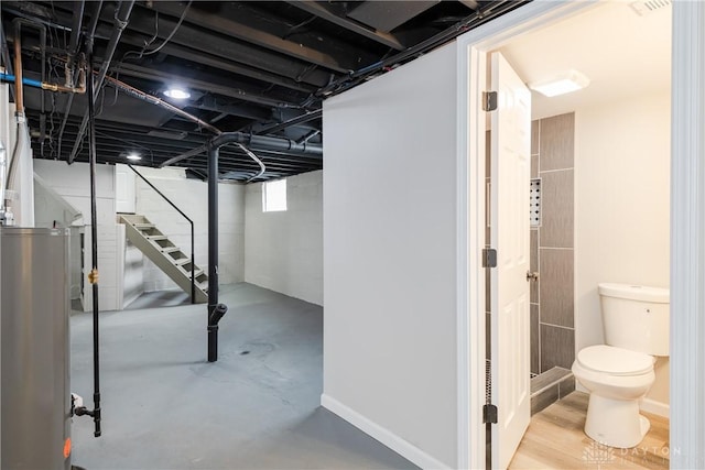 basement with gas water heater and stairway