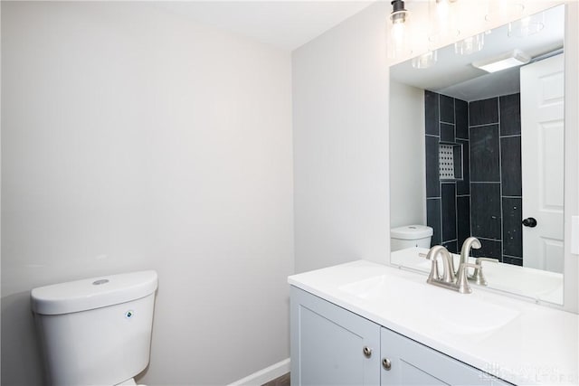 bathroom featuring vanity, toilet, and baseboards