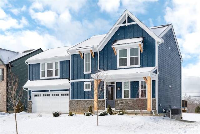 modern inspired farmhouse featuring an attached garage, stone siding, and board and batten siding