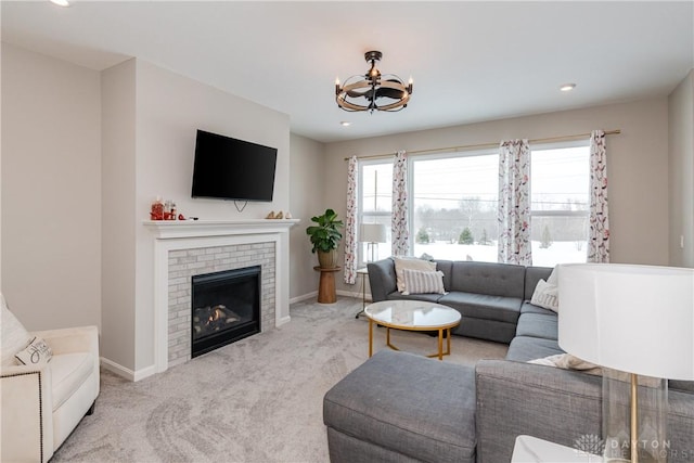 living area with plenty of natural light, light colored carpet, and a fireplace