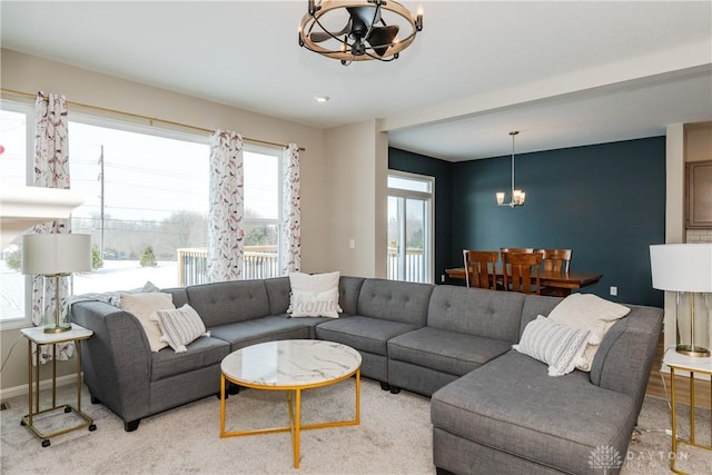 living area featuring baseboards and a notable chandelier