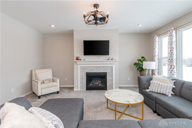 living room with light carpet, a fireplace, an inviting chandelier, and baseboards