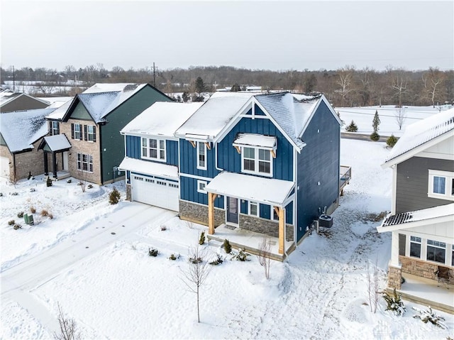 view of front of property with a garage, stone siding, cooling unit, and board and batten siding