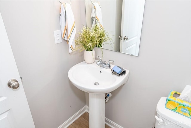 bathroom featuring toilet, baseboards, and wood finished floors