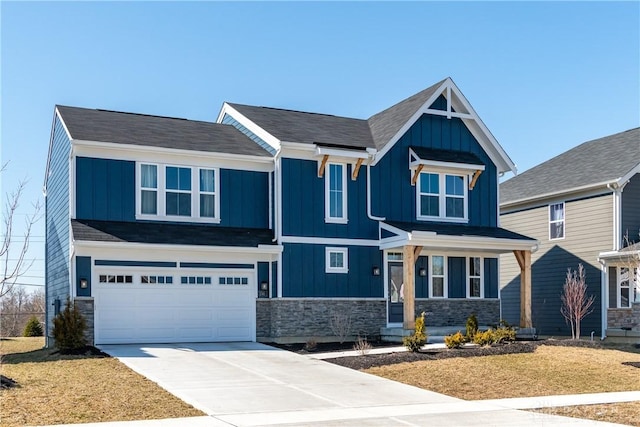 craftsman house featuring board and batten siding, stone siding, driveway, and a garage