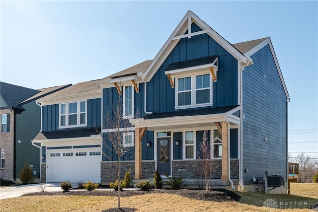 view of front of property with stone siding, concrete driveway, board and batten siding, and an attached garage