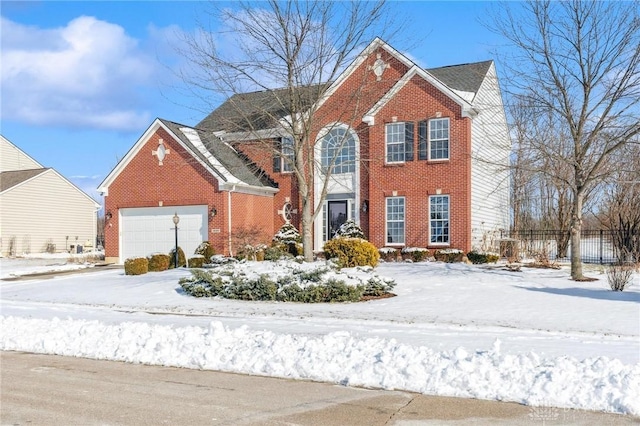 colonial house featuring brick siding, an attached garage, and fence