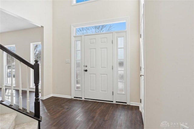 entryway with stairs, dark wood finished floors, and baseboards