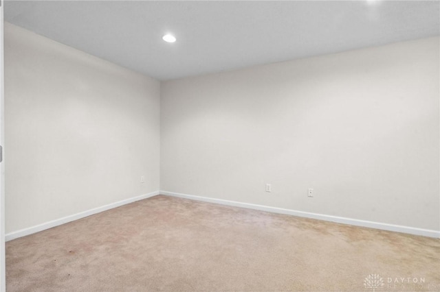 empty room featuring recessed lighting, baseboards, and light carpet