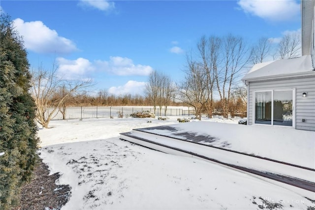 yard covered in snow featuring fence