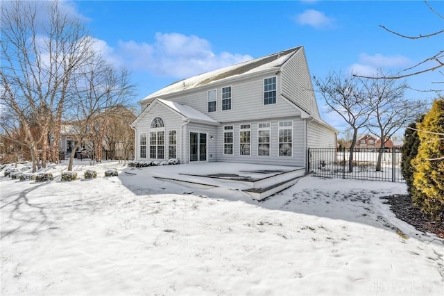 snow covered property with fence