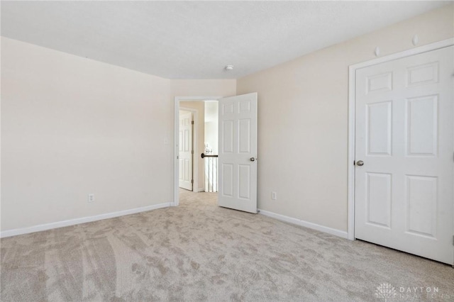 unfurnished bedroom featuring baseboards and carpet flooring